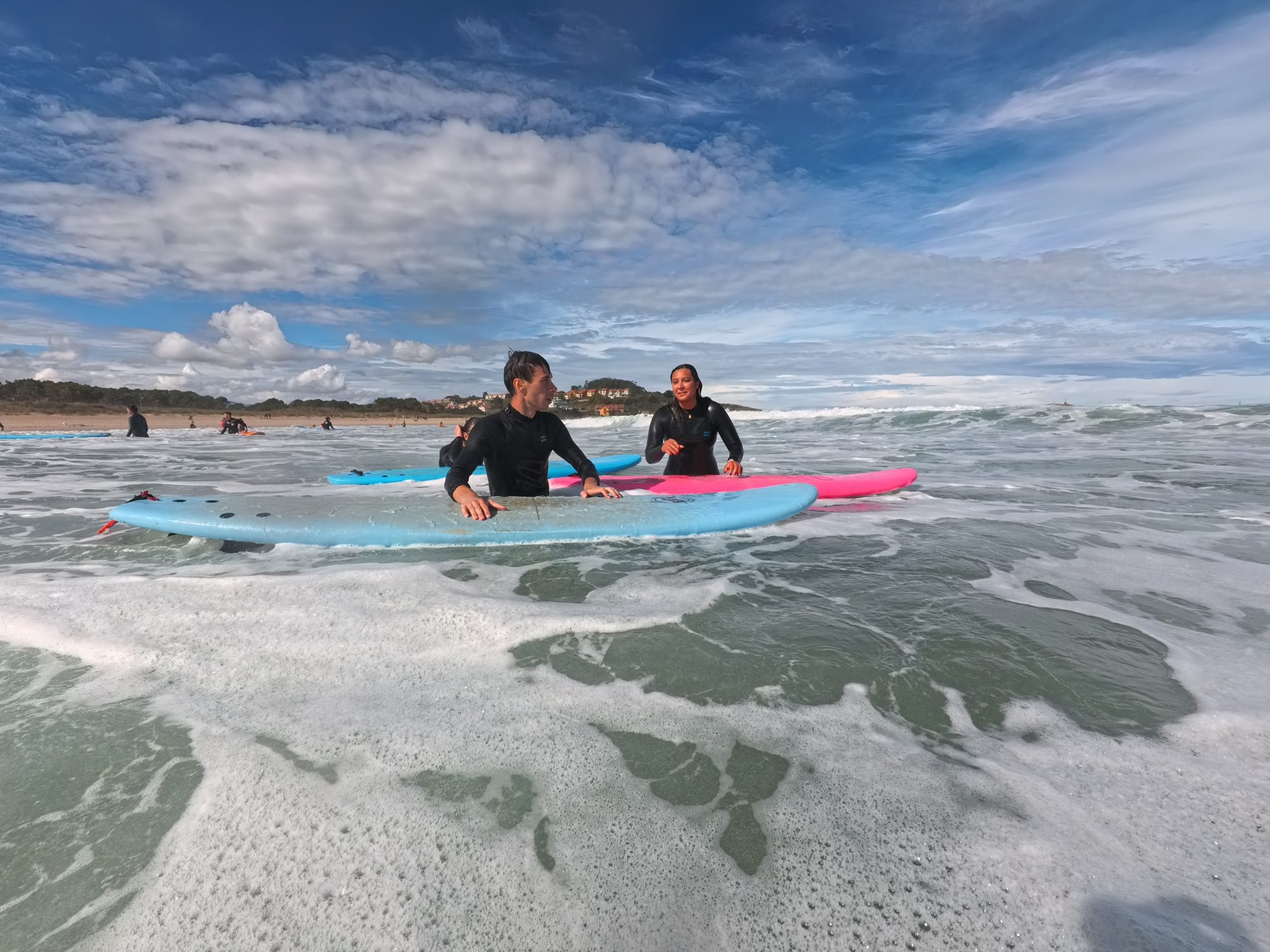 Jóvenes surfeando entre olas