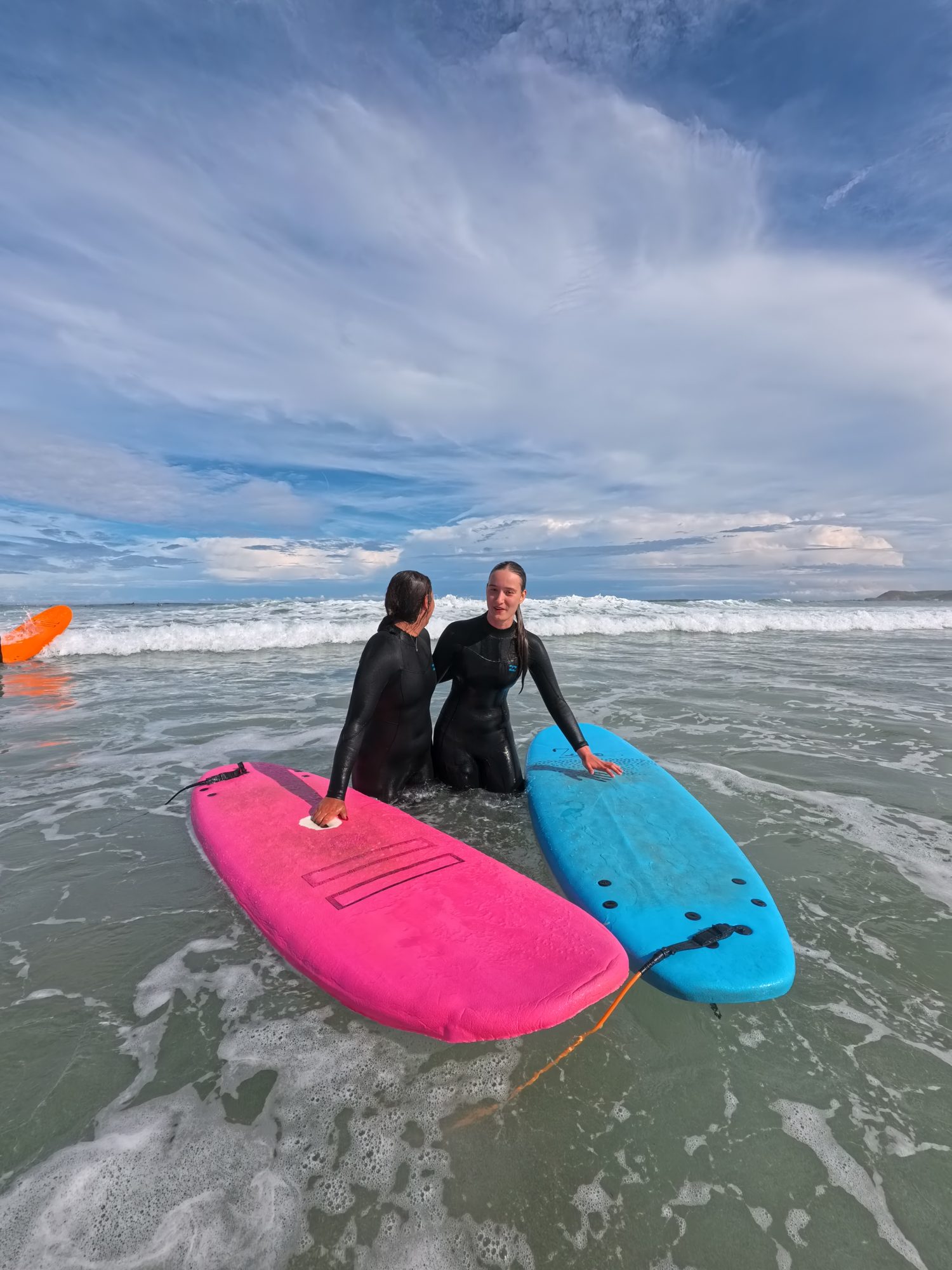 Dos jóvenes con tablas de surf en la playa